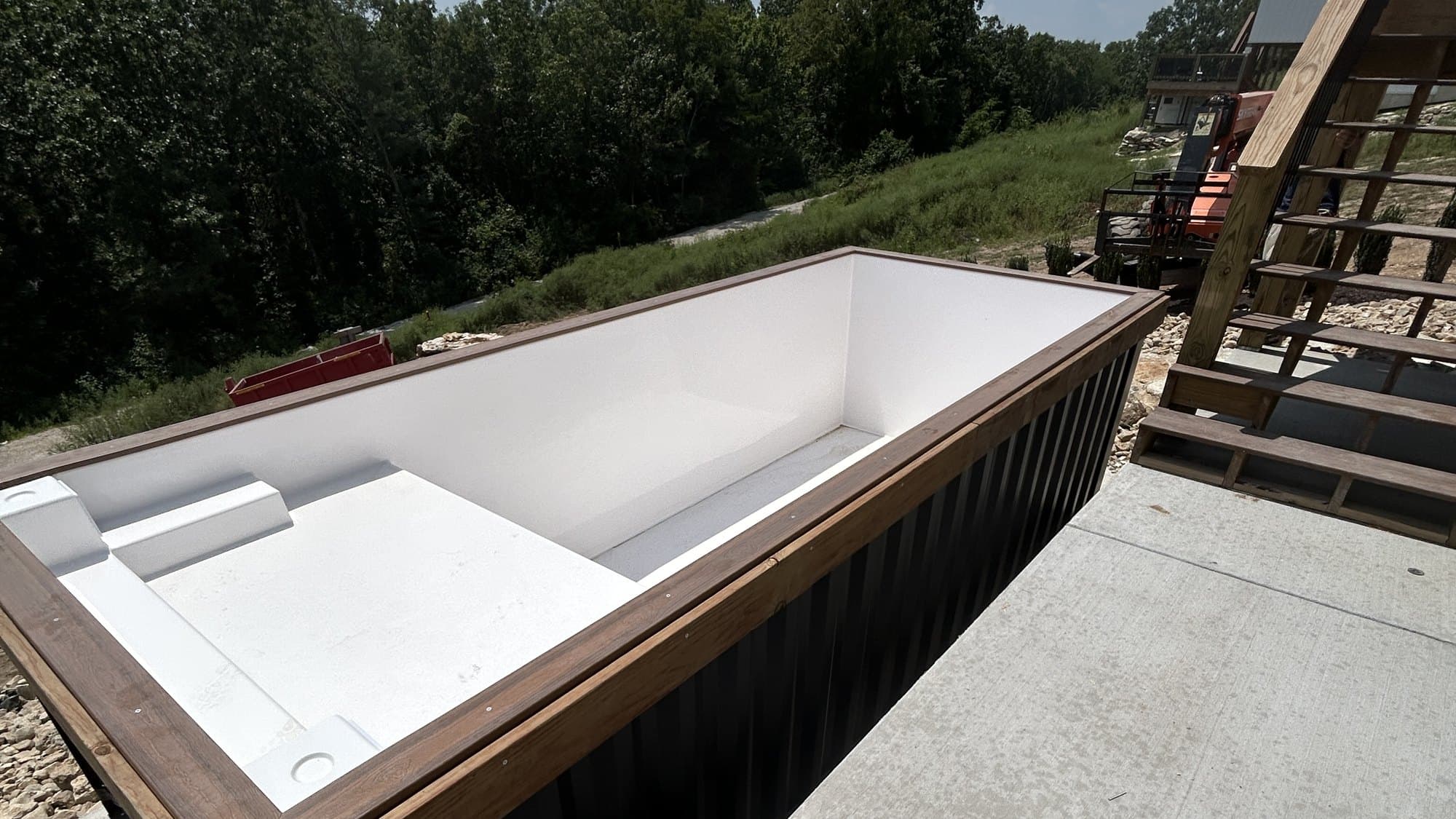 A container pool set on a prepared pad beside a home